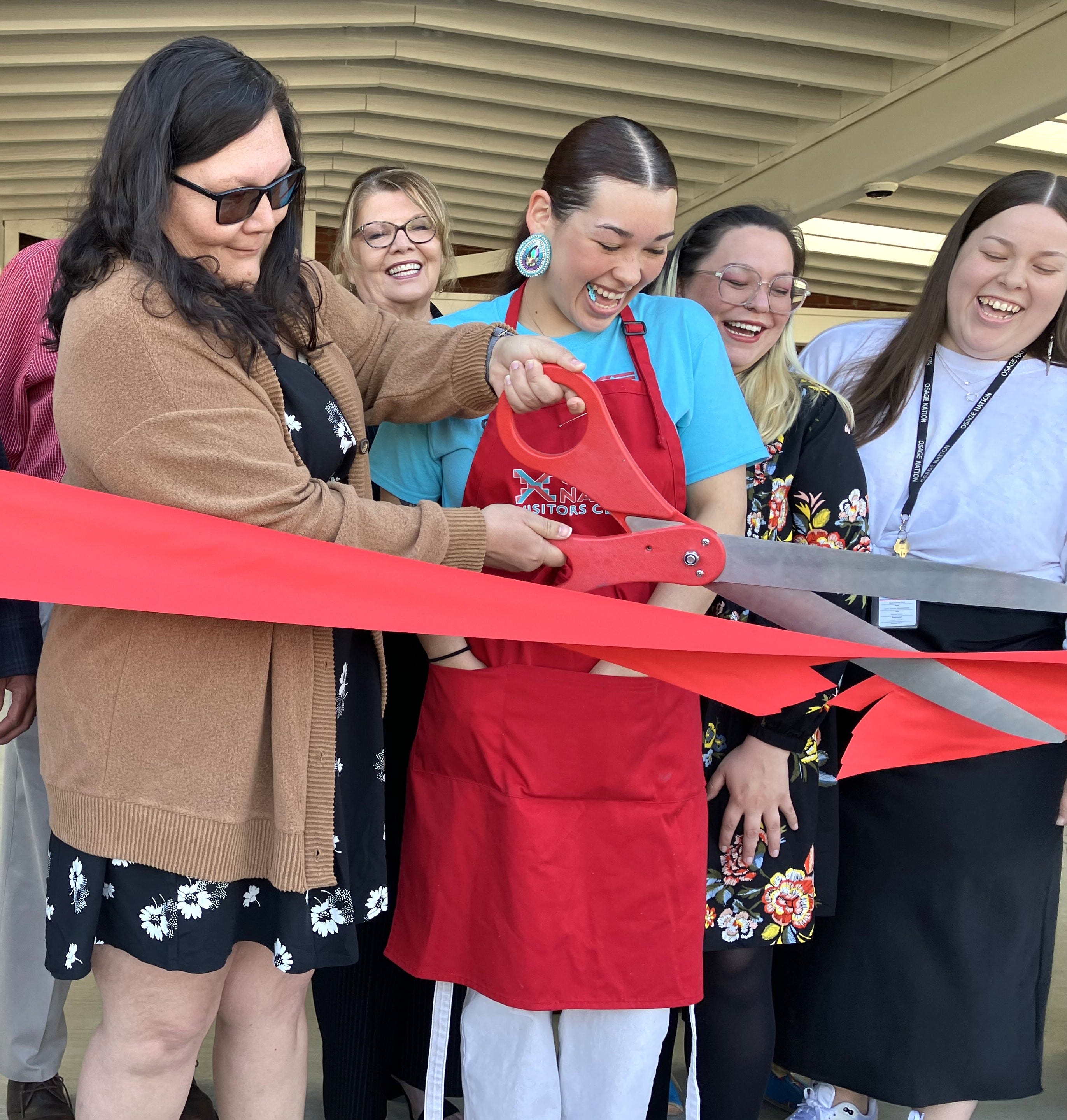 Addie Hudgins, left, director of the newly reopened Osage Nation Visitors Center, cuts the ceremonial ribbon April 17.